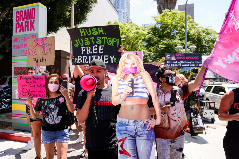   #ФрееБритнеи активисти протестују у Лос Анђелес Гранд Парку током конзерваторског саслушања за Бритни Спирс 23. јуна 2021. у Лос Анђелесу, Калифорнија. Очекује се да ће се Спирс обратити суду на даљину. Спирс је смештена у конзерваторско друштво којим управља њен отац, Џејми Спирс, и адвокат, који контролише њену имовину и пословање, након њене присилне хоспитализације ради менталне неге 2008.