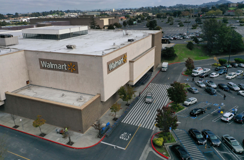   У погледу из ваздуха, купци шетају паркингом Волмарт продавнице 16. новембра 2021. у Ричмонду, Калифорнија. Валмарт је пријавио зараду у трећем кварталу бољу од очекиване са приходима од 140,53 милијарде долара, или 1,45 долара по акцији, у поређењу са очекивањима аналитичара од 135,60 милијарди долара, или 1,40 долара по акцији.