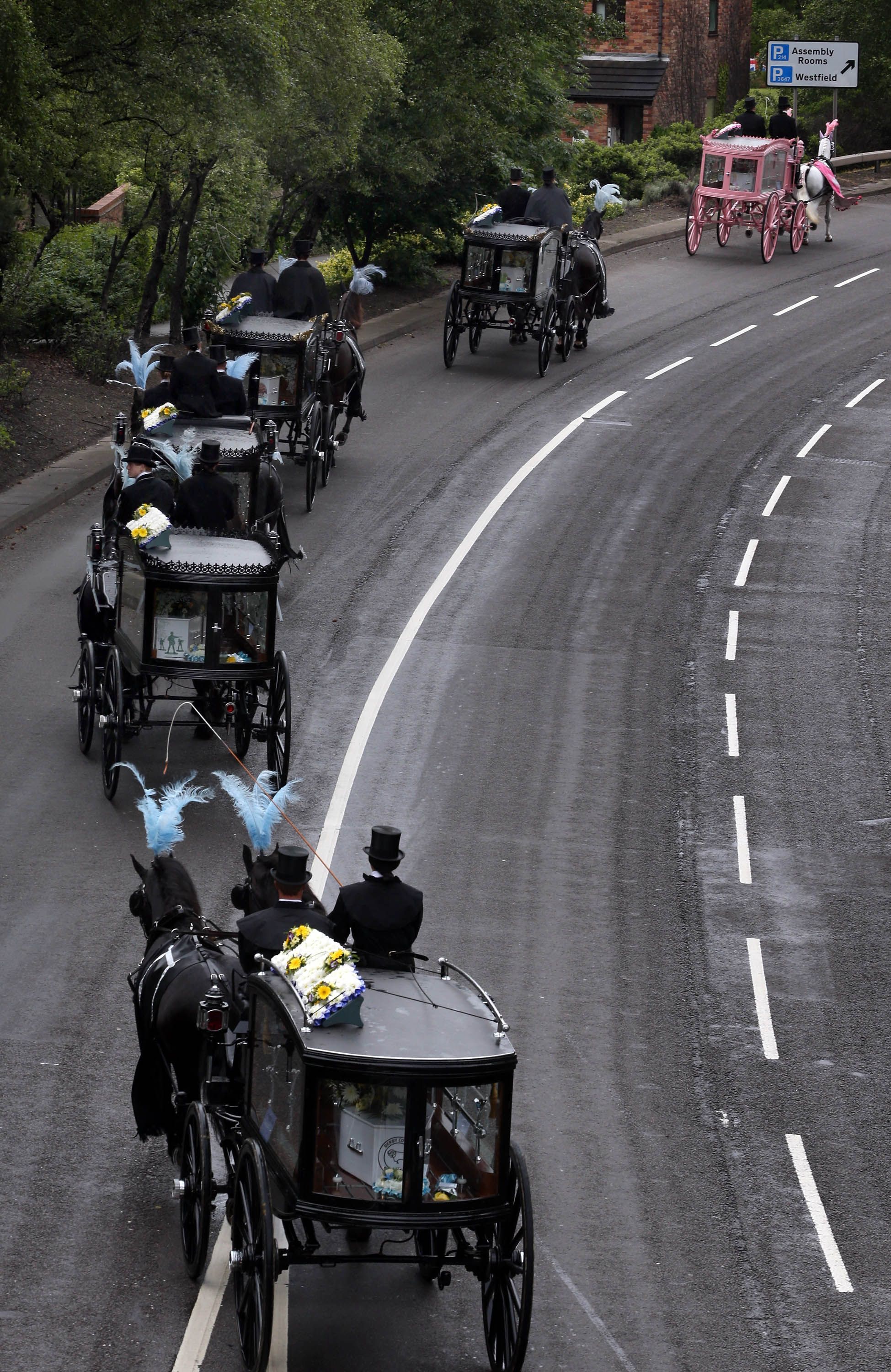 Carros funerários puxados por cavalos viajam para St. Mary