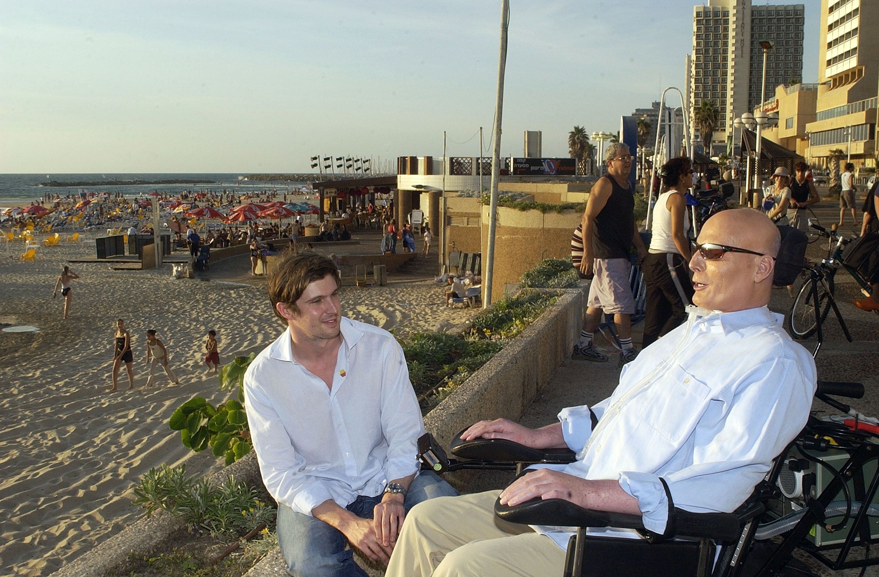 El ex actor Christopher Reeve y su hijo Matthew hablan en el paseo marítimo con vistas al mar Mediterráneo el 1 de agosto de 2003, en Tel Aviv, Israel. (Getty)